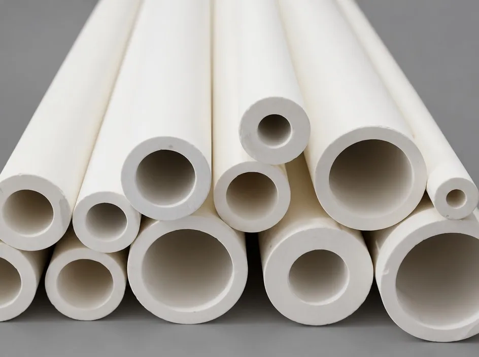 A bundle of white alumina tubes of different diameters stacked on a grey studio ground, their open ends facing the camera.