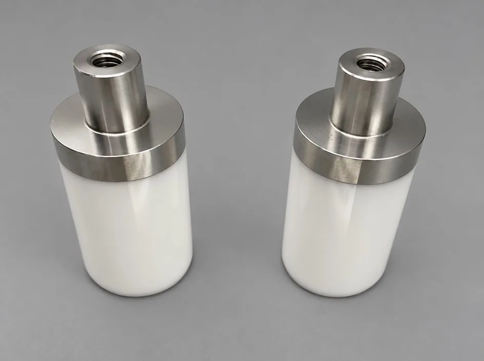 Two white cylindrical bodies on a grey studio ground, each capped with a machined metal head carrying a threaded bore.