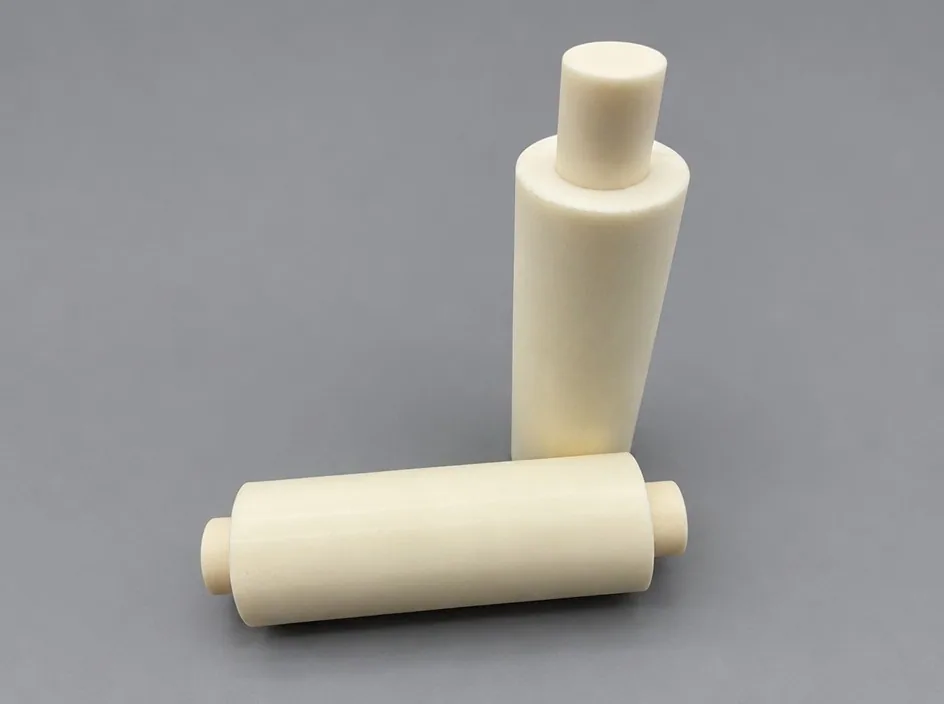 Two white cylinders on a grey studio ground, one stepped with a centred boss and one with an eccentric boss.
