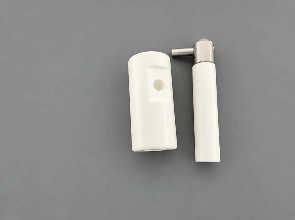A white block with a through bore beside a white shaft fitted with a metal head and a short side pin, on a grey studio ground.