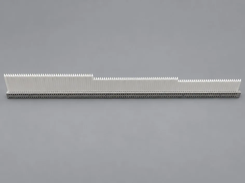 A long white ribbed insert seated on a perforated metal base strip, photographed on a grey studio ground.