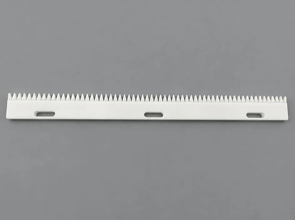 A long white bar on a grey studio ground with a row of fine saw teeth along one edge and three oval slots through the body.