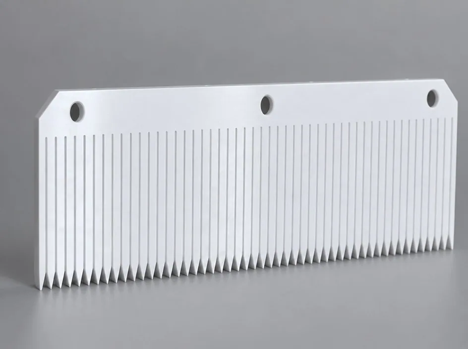 A white plate on a grey studio ground cut along its lower edge into a dense row of fine slots, with three bores through the solid upper margin.