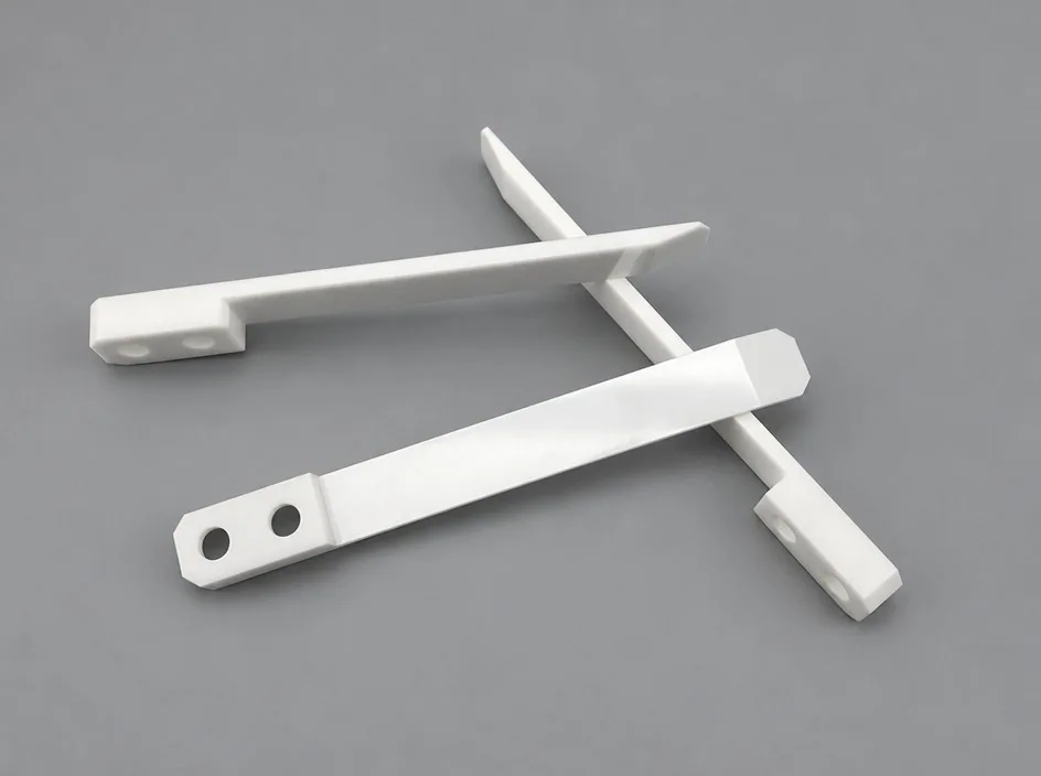 Three thin white blade arms on a grey studio ground, each with a widened end carrying two fixing bores.