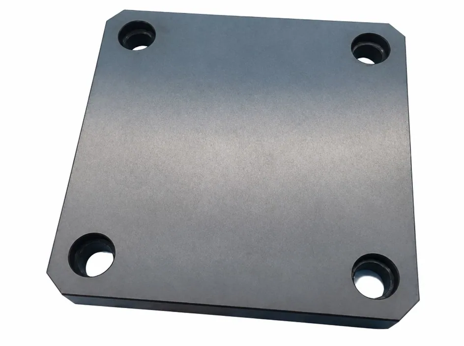 A square silicon nitride plate with chamfered corners and four counterbored holes, photographed on a white ground.