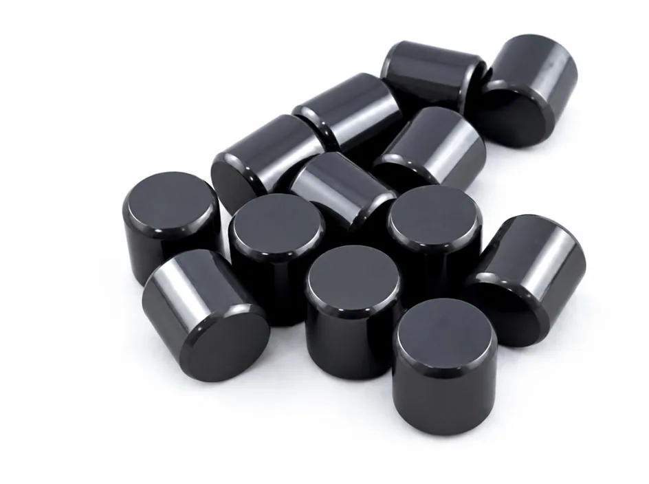 Thirteen short silicon nitride cylinders of similar diameter, scattered on a white ground.