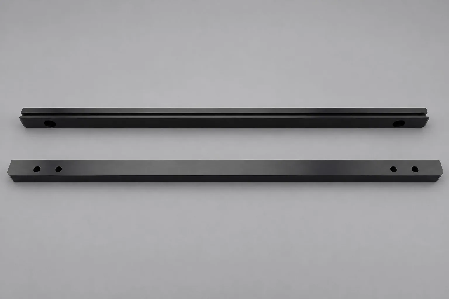 Two long dark zirconia bars on a light ground, each with a lengthwise groove and drilled holes near both ends.